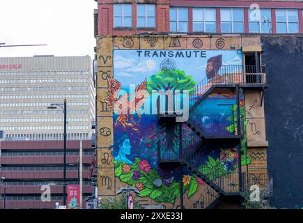 Un grande murale su un vecchio edificio a Manchester, Regno Unito. Il murale raffigura una fenice, un albero della vita, una donna e un uomo. Foto Stock