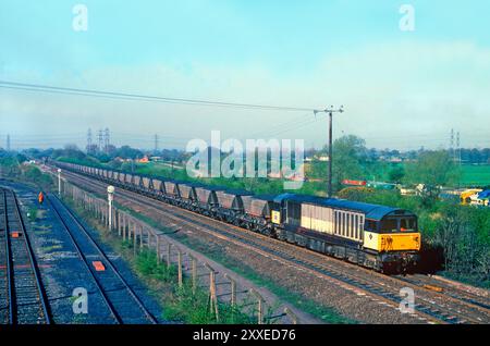 Una locomotiva diesel classe 58 numero 58013 si dirige a nord verso Stenson Junction con un MGR di carbone carico che lavora il 13 aprile 1995. Foto Stock
