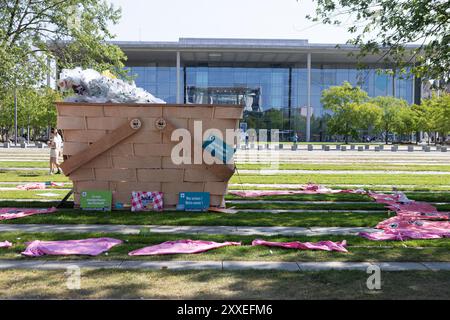 Berlino, Germania, 24 settembre 2024. Gli attivisti ambientalisti prendono parte a un picnic di protesta a livello nazionale organizzato dal WWF Germany contro la crisi plastica di fronte alla Cancelleria federale di Berlino. I manifestanti si riuniscono con striscioni colorati e un gigantesco cestino simbolico da picnic pieno di rifiuti di plastica, chiedendo un forte trattato globale delle Nazioni Unite per porre fine all'inquinamento della plastica durante i negoziati ONU in corso. Felix Wolf/Alamy Live News Foto Stock