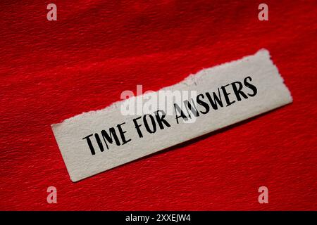 Messaggio Time for Answers scritto su carta strappata con sfondo rosso. Simbolo tempo concettuale per le risposte. Copia spazio. Foto Stock
