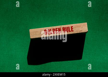 Messaggio con regola d'oro scritto su un blocco di legno con sfondo verde. Simbolo della regola d'oro concettuale. Copia spazio. Foto Stock