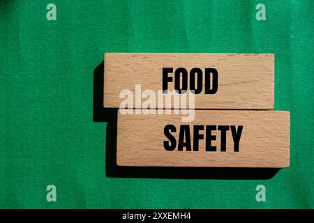 Messaggio di sicurezza alimentare scritto su blocchi di legno con sfondo verde. Simbolo concettuale di sicurezza alimentare. Copia spazio. Foto Stock