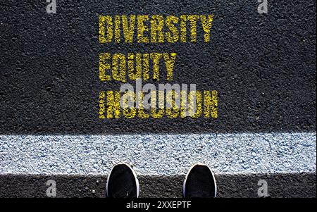 Messaggio di diversità equità e inclusione scritto sulla strada asfaltata. Simbolo DEI Diversity Equity Inclusion concettuale. Copia spazio. Foto Stock