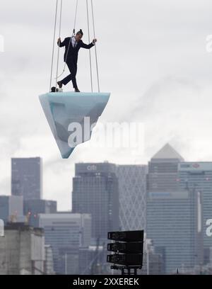 La prima europea di performance art THAW, uno spettacolo aereo di 8 ore si è esibito su 2,5 tonnellate di ghiaccio durante il Greenwich and Docklands International Festival nell'est di Londra. Creato dalla compagnia teatrale australiana LEGS ON THE WALL in risposta ai devastanti incendi boschivi del 2019/20, THAW porta i londinesi faccia a faccia con l'urgente necessità di un'azione globale per il clima. Questa produzione aerea è stata eseguita su un blocco di ghiaccio di 2,5 tonnellate che aumenta la potenza e l'urgenza mentre il ghiaccio, sospeso su una gru in alto sopra un iconico paesaggio docklands, si scioglie gradualmente. Data foto: Sabato agosto Foto Stock