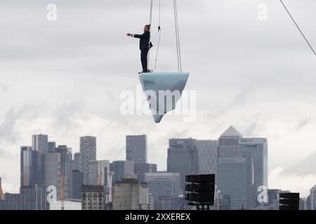 La prima europea di performance art THAW, uno spettacolo aereo di 8 ore si è esibito su 2,5 tonnellate di ghiaccio durante il Greenwich and Docklands International Festival nell'est di Londra. Creato dalla compagnia teatrale australiana LEGS ON THE WALL in risposta ai devastanti incendi boschivi del 2019/20, THAW porta i londinesi faccia a faccia con l'urgente necessità di un'azione globale per il clima. Questa produzione aerea è stata eseguita su un blocco di ghiaccio di 2,5 tonnellate che aumenta la potenza e l'urgenza mentre il ghiaccio, sospeso su una gru in alto sopra un iconico paesaggio docklands, si scioglie gradualmente. Data foto: Sabato agosto Foto Stock