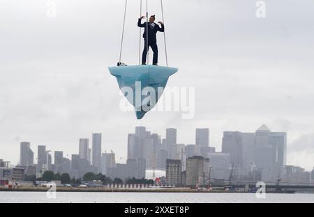 La prima europea di performance art THAW, uno spettacolo aereo di 8 ore si è esibito su 2,5 tonnellate di ghiaccio durante il Greenwich and Docklands International Festival nell'est di Londra. Creato dalla compagnia teatrale australiana LEGS ON THE WALL in risposta ai devastanti incendi boschivi del 2019/20, THAW porta i londinesi faccia a faccia con l'urgente necessità di un'azione globale per il clima. Questa produzione aerea è stata eseguita su un blocco di ghiaccio di 2,5 tonnellate che aumenta la potenza e l'urgenza mentre il ghiaccio, sospeso su una gru in alto sopra un iconico paesaggio docklands, si scioglie gradualmente. Data foto: Sabato agosto Foto Stock