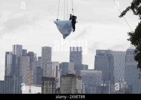 La prima europea di performance art THAW, uno spettacolo aereo di 8 ore si è esibito su 2,5 tonnellate di ghiaccio durante il Greenwich and Docklands International Festival nell'est di Londra. Creato dalla compagnia teatrale australiana LEGS ON THE WALL in risposta ai devastanti incendi boschivi del 2019/20, THAW porta i londinesi faccia a faccia con l'urgente necessità di un'azione globale per il clima. Questa produzione aerea è stata eseguita su un blocco di ghiaccio di 2,5 tonnellate che aumenta la potenza e l'urgenza mentre il ghiaccio, sospeso su una gru in alto sopra un iconico paesaggio docklands, si scioglie gradualmente. Data foto: Sabato agosto Foto Stock