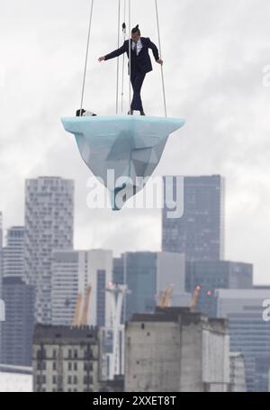 La prima europea di performance art THAW, uno spettacolo aereo di 8 ore si è esibito su 2,5 tonnellate di ghiaccio durante il Greenwich and Docklands International Festival nell'est di Londra. Creato dalla compagnia teatrale australiana LEGS ON THE WALL in risposta ai devastanti incendi boschivi del 2019/20, THAW porta i londinesi faccia a faccia con l'urgente necessità di un'azione globale per il clima. Questa produzione aerea è stata eseguita su un blocco di ghiaccio di 2,5 tonnellate che aumenta la potenza e l'urgenza mentre il ghiaccio, sospeso su una gru in alto sopra un iconico paesaggio docklands, si scioglie gradualmente. Data foto: Sabato agosto Foto Stock