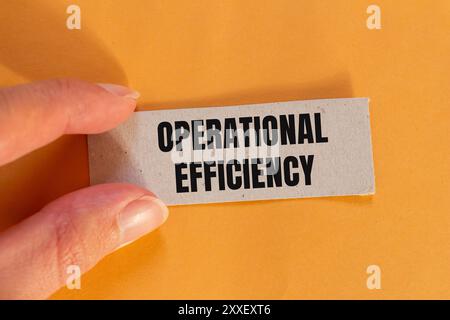 Messaggio di efficienza operativa scritto su un foglio di carta strappato con sfondo arancione. Simbolo di efficienza operativa concettuale. Copia spazio. Foto Stock