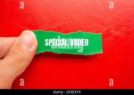 Messaggio d'ordine speciale scritto su carta verde strappata con sfondo rosso. Simbolo di ordine speciale concettuale. Copia spazio. Foto Stock