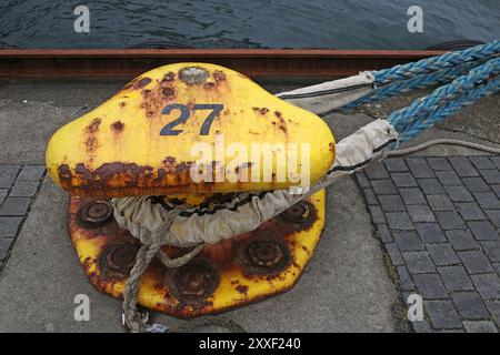 Dissuasore giallo arrugginito con la corda di una nave. E' il dissuasore numero 27 Foto Stock