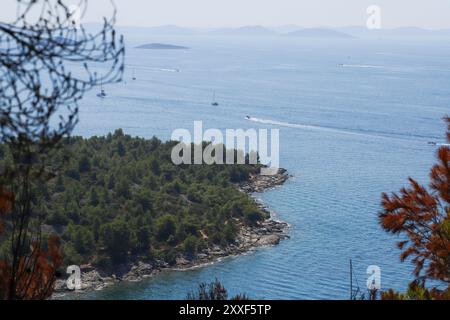 Wildfire su Murter, Croazia, luglio 30 2024. Foresta bruciata dal mare Adriatico. Laguna blu sotto una foresta morta. Clima caldo e secco in Europa Foto Stock