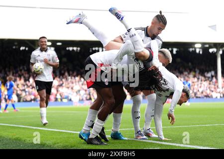 Alex Iwobi (centro) del Fulham celebra il secondo goal della partita con i compagni di squadra durante la partita di Premier League al Craven Cottage di Londra. Data foto: Sabato 24 agosto 2024. Foto Stock