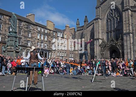 Edinburgh Festival Fringe, Royal Mile, Edimburgo, Scotlnd, Regno Unito. 24 agosto 2024. Sabato finale affollato sulla High Street mentre il sole splende tra le docce per coloro che cercano intrattenimento da Street Performers. Nella foto: Christian Starr cammina la sua corda di fuoco in Piazza del Parlamento. Credito: Arch White/alamy notizie dal vivo. Foto Stock