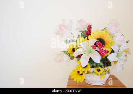 Studio orizzontale STILL Life girato di un vaso con fiori di plastica gialli e bianchi. Sfondo con disposizione dei girasoli primaverili con spazio per le copie. Foto Stock