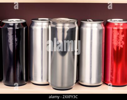 Diverse lattine di metallo con una bevanda, macro, isolate su sfondo bianco. Foto Stock