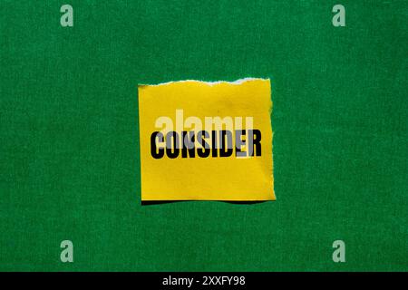 Considerare il messaggio scritto su un foglio di carta giallo strappato con sfondo verde. Simbolo concettuale da considerare. Copia spazio. Foto Stock