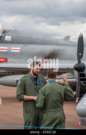 due piloti di jet fighter che indossano tute da volo parlano accanto al jet da caccia veloce al tatuaggio riat royal international air raf fairford nel gloucestershire Foto Stock