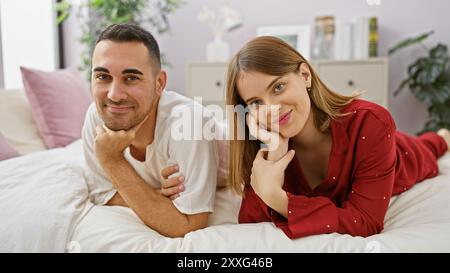 Una coppia amorevole che si rilassa insieme su un letto in un'accogliente camera da letto, irradiando felicità e intimità. Foto Stock