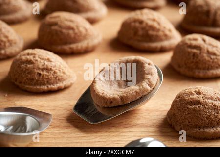 Biscotti di Natale fatti in casa appena sfornati sotto forma di noci in stampi di latta Foto Stock