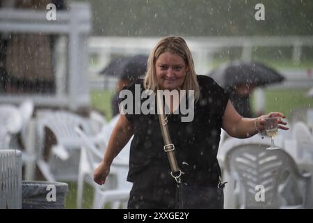 Windsor, Berkshire, UK. 24th August, 2024. Racegoers at Royal Windsor Racecourse didn't let heavy rain and thunderstorms spoil their evening at the Summer Closing Party in Windsor, Berkshire. Credit: Maureen McLean/Alamy Live News Stock Photo