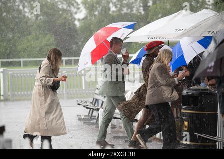 Windsor, Berkshire, UK. 24th August, 2024. Racegoers at Royal Windsor Racecourse didn't let heavy rain and thunderstorms spoil their evening at the Summer Closing Party in Windsor, Berkshire. Credit: Maureen McLean/Alamy Live News Stock Photo