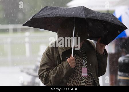 Windsor, Berkshire, Regno Unito. 24 agosto 2024. I Racegoers del Royal Windsor Racecourse non lasciarono che piogge intense e temporali rovinassero la loro serata al Summer Closing Party a Windsor, Berkshire. Crediti: Maureen McLean/Alamy Live News Foto Stock