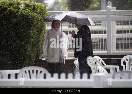 Windsor, Berkshire, Regno Unito. 24 agosto 2024. I Racegoers del Royal Windsor Racecourse non lasciarono che piogge intense e temporali rovinassero la loro serata al Summer Closing Party a Windsor, Berkshire. Crediti: Maureen McLean/Alamy Live News Foto Stock