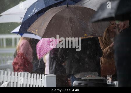 Windsor, Berkshire, UK. 24th August, 2024. Racegoers at Royal Windsor Racecourse didn't let heavy rain and thunderstorms spoil their evening at the Summer Closing Party in Windsor, Berkshire. Credit: Maureen McLean/Alamy Live News Stock Photo