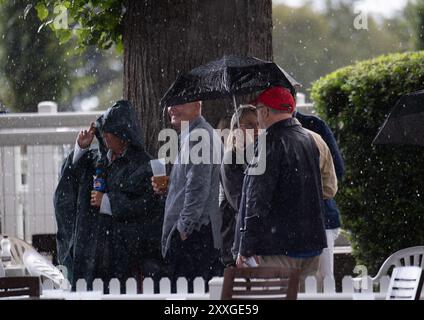 Windsor, Berkshire, Regno Unito. 24 agosto 2024. I Racegoers del Royal Windsor Racecourse non lasciarono che piogge intense e temporali rovinassero la loro serata al Summer Closing Party a Windsor, Berkshire. Crediti: Maureen McLean/Alamy Live News Foto Stock