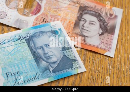 Banconote vecchie e nuove in polimero del Regno Unito - una banconota da dieci libbre con la testa della regina Elisabetta e una banconota da cinque libbre con la testa di re Carlo Foto Stock