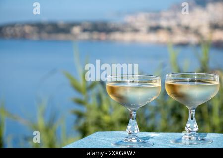 Spumante freddo, cava o champagne in due bicchieri da coupé sul tavolo con vista mare vicino a Mentone e Monte Carlo, Costa Azzurra, la Francia è estate Foto Stock