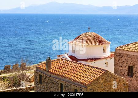 Monemvasia chiesa, vecchio rosso case in mattoni, tetti in città antica e blue sea view, Peloponneso e Grecia. Tradizionale architettura greca sullo sfondo Foto Stock