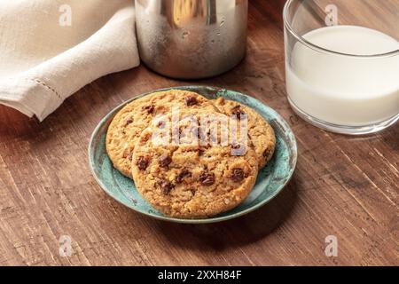 Un primo piano di biscotti al cioccolato con latte al buio su un rustico sfondo di legno con un posto per il testo Foto Stock