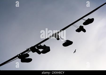 Le scarpe smaltite sono appese a una linea nel Foto Stock