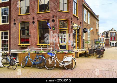 Delft, Paesi Bassi, 6 aprile 2016: Vista colorata sulla strada con tradizionali case olandesi e biciclette nel centro della popolare destinazione olandese Foto Stock