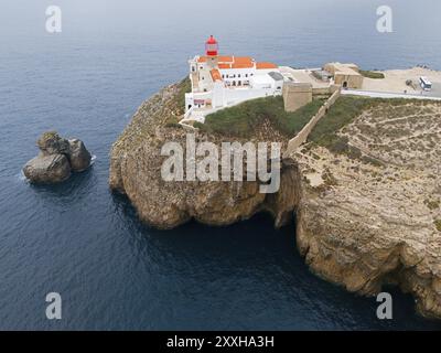 Un faro rosso e edifici bianchi su una scogliera rocciosa che si affaccia sull'oceano, un'atmosfera isolata, vista aerea, faro, Cabo de Sao Vicente, Capo Foto Stock