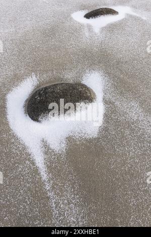 Pietre innevate su una spiaggia sabbiosa, Unstad, Vestvagoy, Lofoten, Nordland, Norvegia, marzo 2015, Europa Foto Stock