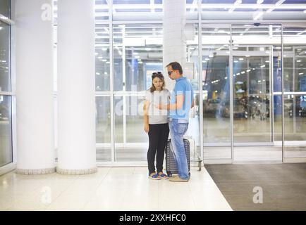 Giovane coppia in gravidanza con la valigia in aeroporto o stazione Foto Stock