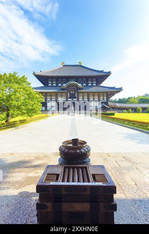 Bruciatore di incenso alla testa del sentiero che conduce a Daibutsuden, la sala del grande Buddha, al complesso del tempio Todai-ji, in una splendida mattinata blu del cielo vuoto di turisti Foto Stock