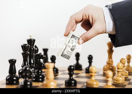 Business man mano che tiene dollar cambio ingiusto giocare gioco di scacchi Foto Stock