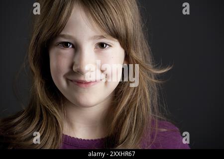 Ritratto di una bambina in un maglione viola Foto Stock