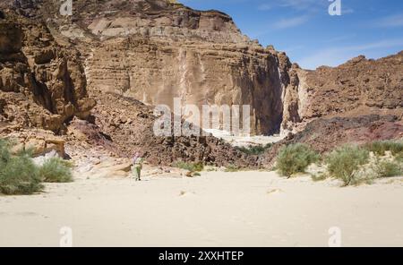 Bedouin va in un villaggio nel deserto in mezzo alle alte montagne rocciose in Egitto Dahab Foto Stock