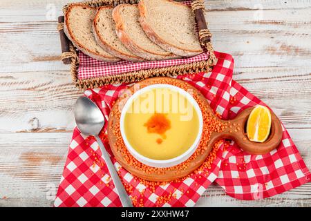 Zuppa di lenticchie della cucina turca, burro fuso e salsa al pepe rosso. Servito con pane e limone. Nome locale; suzme mercimek corbasi. Foto Stock