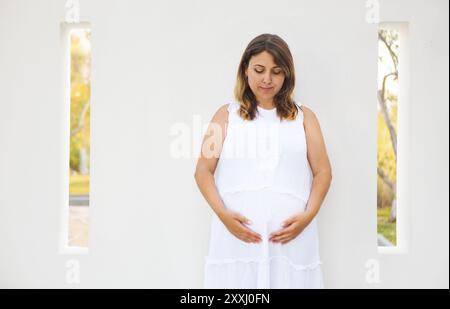 Bella donna incinta rilassante al di fuori del parco Foto Stock