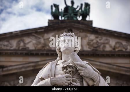 Primo piano della statua di Schiller con sala concerti sullo sfondo e Schiller con un rotolo Foto Stock