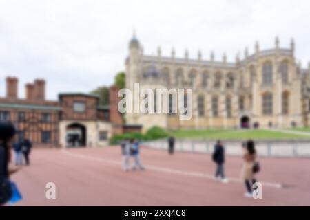 Una vista sfocata di un grande edificio con persone che camminano davanti ad esso. Lo sfondo è leggermente fuori fuoco. Foto Stock