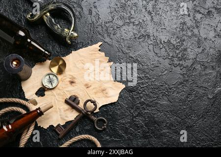 Carta con bussola, vecchie chiavi, candela e bottiglie su sfondo scuro. Concetto di pirata Foto Stock