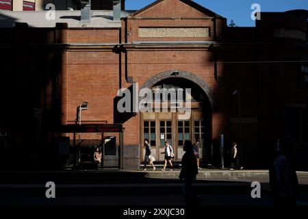 Il vecchio magazzino di mattoni, la porta ad arco e i pannelli delle porte francesi presso l'edificio Paddy's Markets e la ferrovia leggera fermano alla luce e all'ombra del pomeriggio Foto Stock