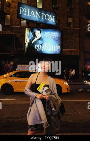 Donna per strada dopo un'esibizione del fantasma dell'Opera a New York City Foto Stock